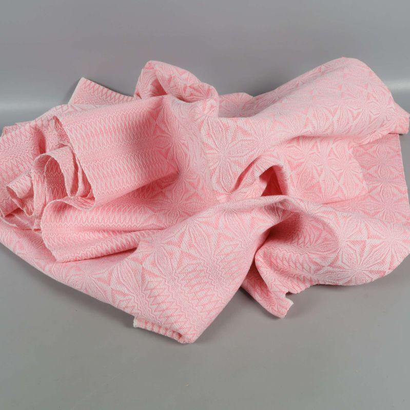 Tyg i ljusrosa och vitt i mjuka veck och rynkor