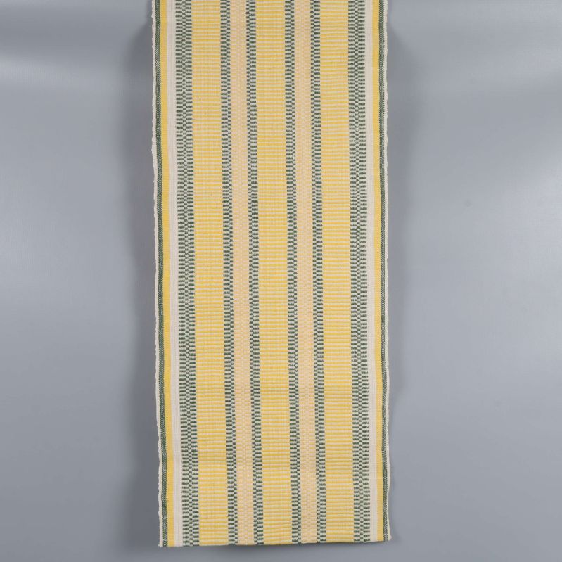 Gulvit löpare med gröna och gula detaljer utlagd plant