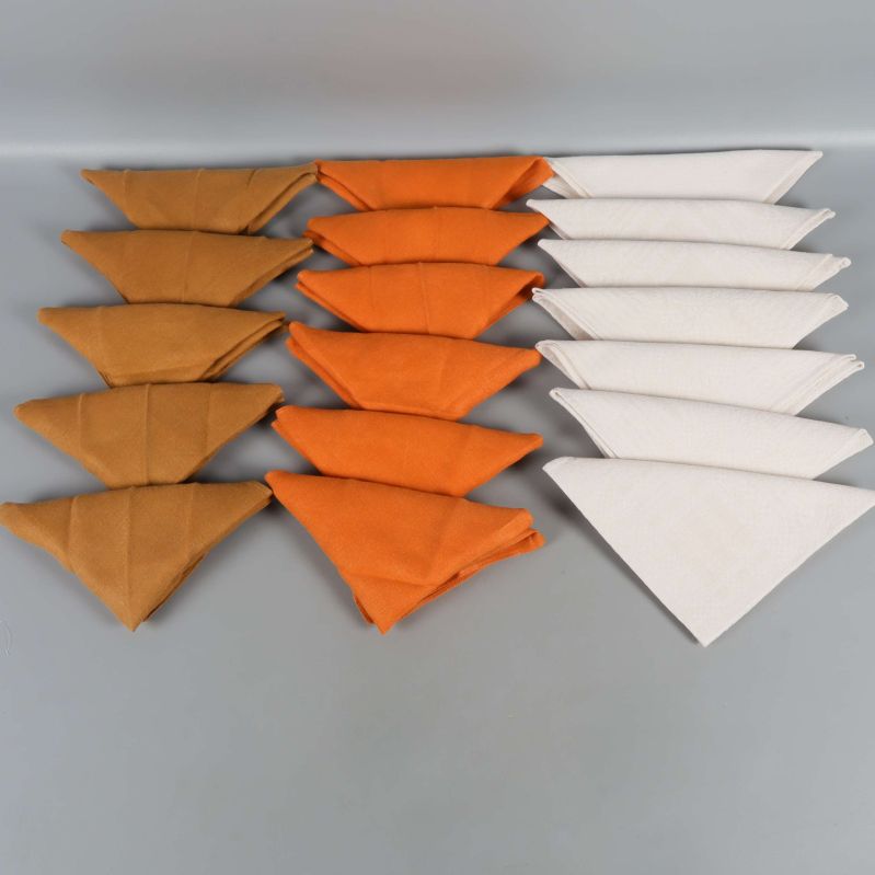 Tre rader vikta servetter i vitt, orange och brunt