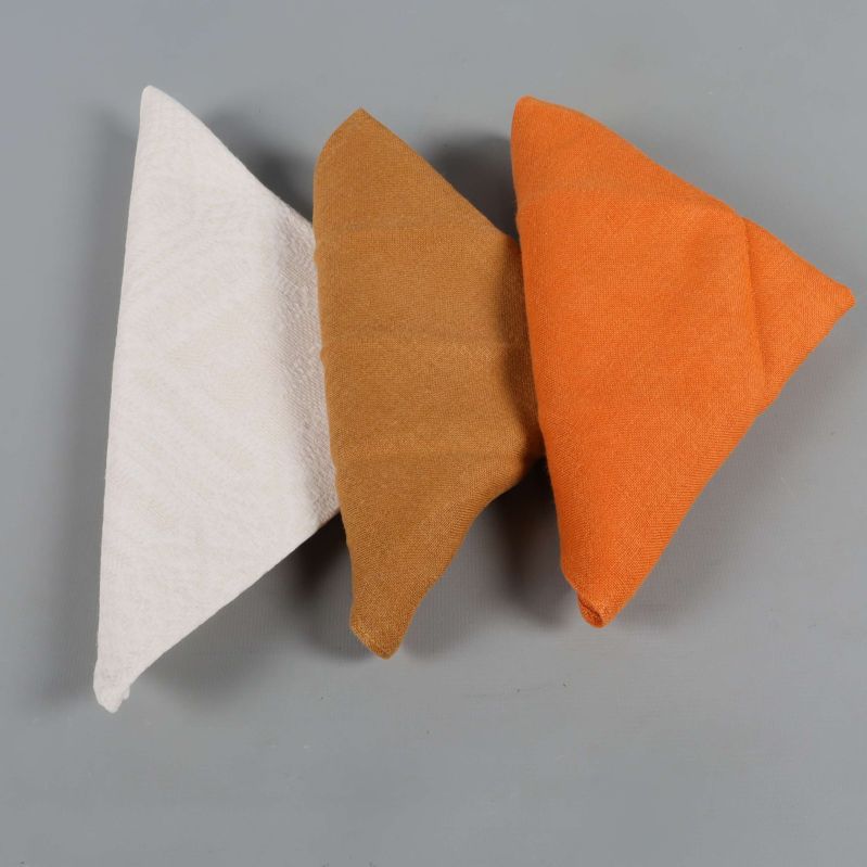 Närbild på tre vikta servetter i olika färger