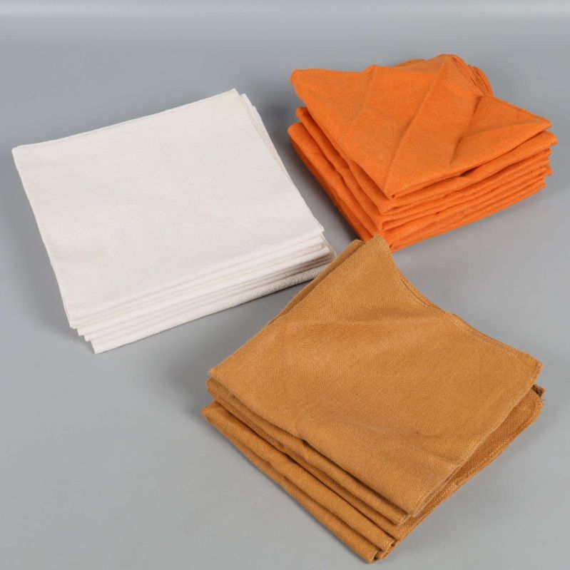 Högar av vikta servetter i gräddvit, orange och brunt