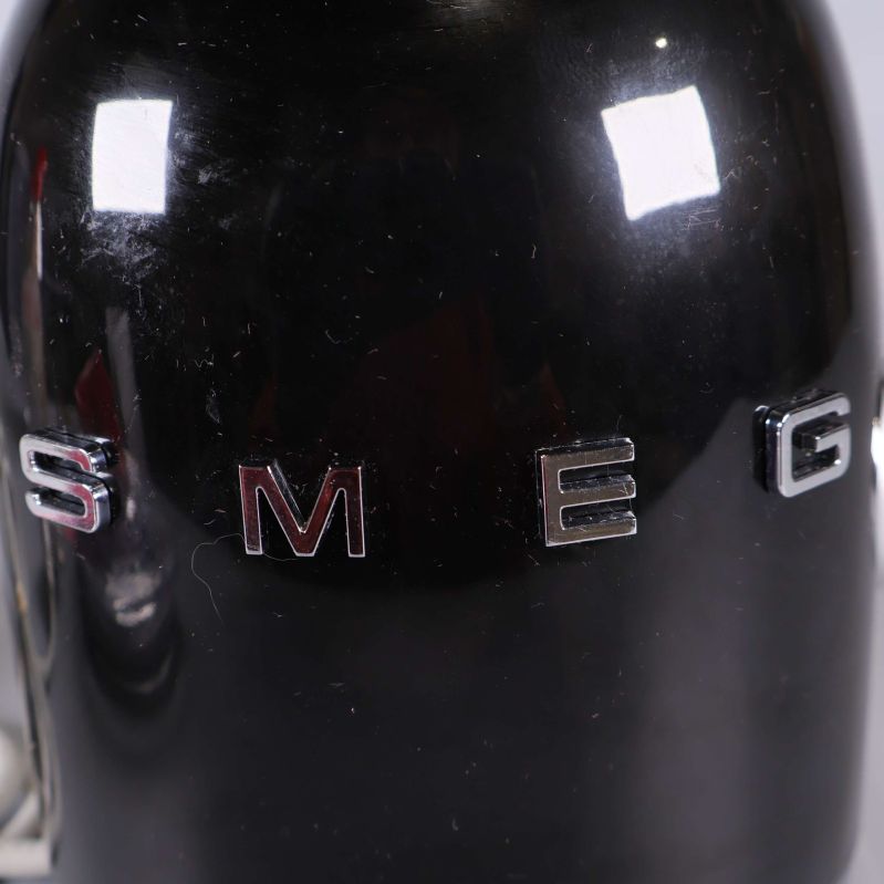 Närbild på svart bas med SMEG-logo i silver