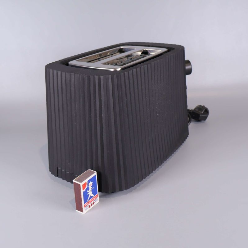 Brödrost i svart med tändsticksask framför för storleksreferens