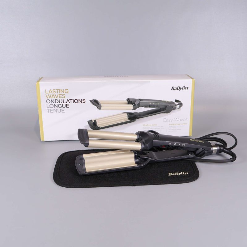 Vågstyler med breda metallfärgade plattor framför originalförpackning