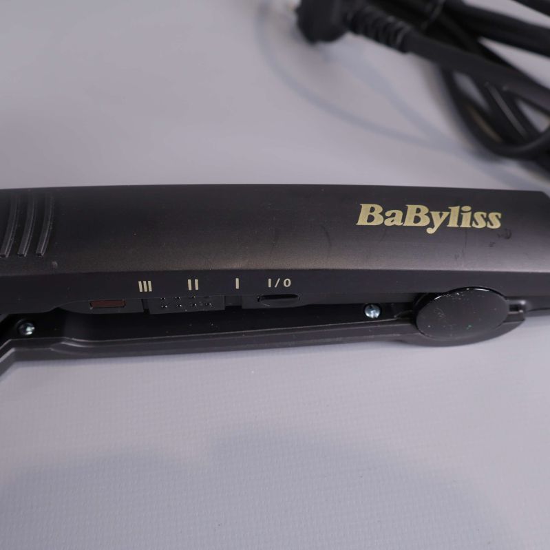 Detaljbild på BaByliss logotyp och inställningar på stylerns handtag