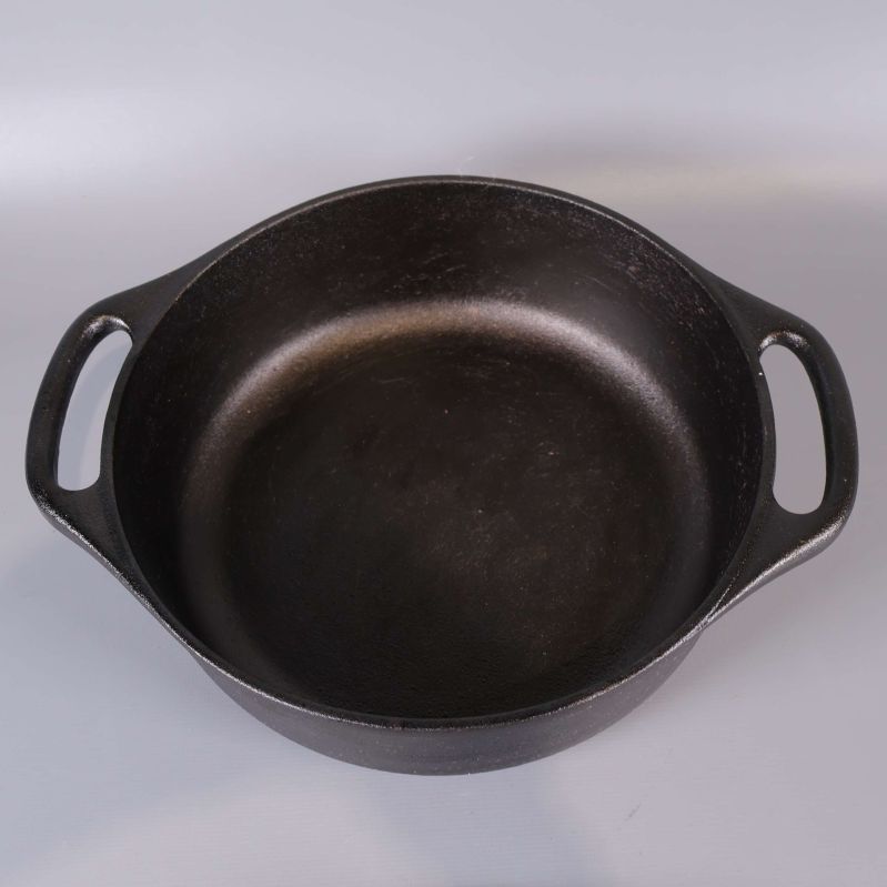 Insida av svart gjutjärnsgryta med två handtag