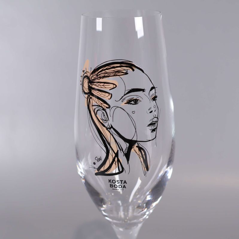 Närbild av champagneglas med ansiktsillustration