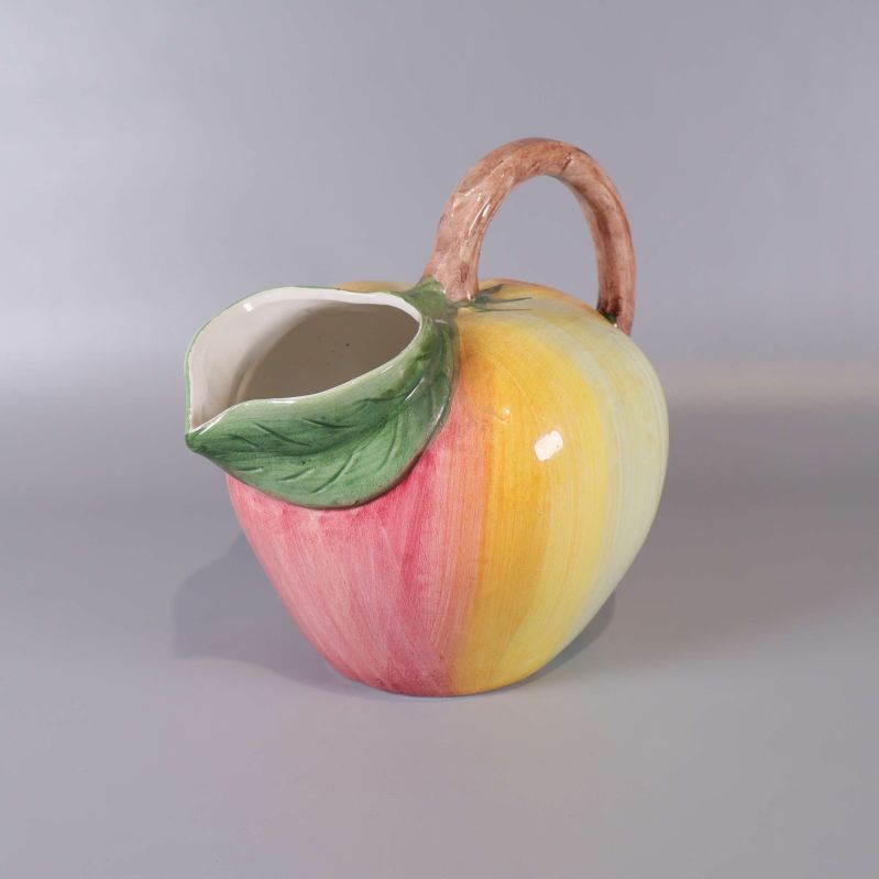 Kanna i keramik formad som en frukt med gröna och rosa toner
