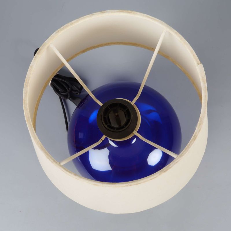 Vy ovanifrån på vit lampskärm och blå fot