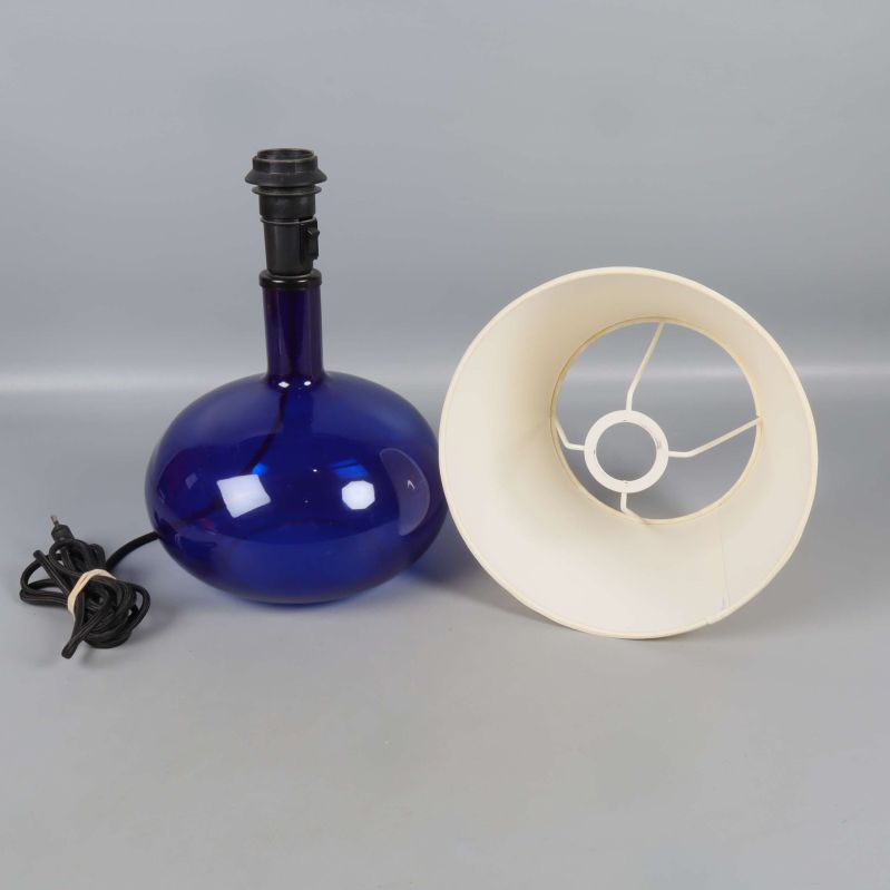 Blå lampfot och vit lampskärm placerade separat