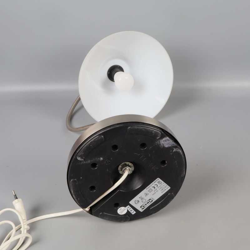 Lampans undersida med etikett och vit textilkabel