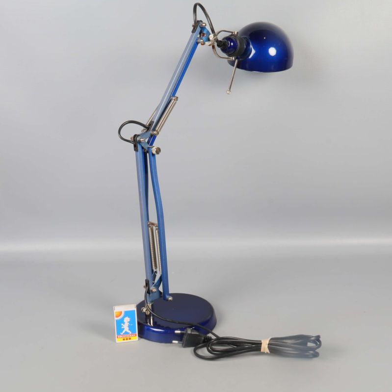 Blå lampa stående med lång arm och sladd synlig på golvet