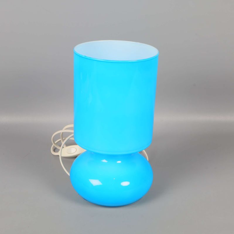 Blå bordslampa med cylinderformad skärm på grå bakgrund