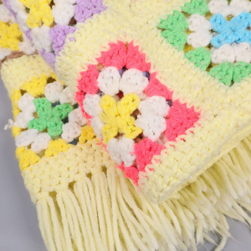 Närbild på virkad pläd och dess franskant