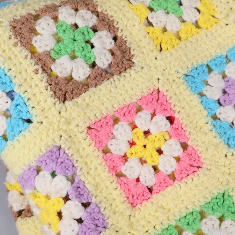 Virkade rutor i olika pastellfärger på pläd