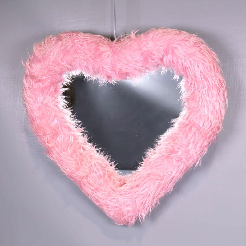 Hjärtspegel med fluffig rosa ram mot grå bakgrund