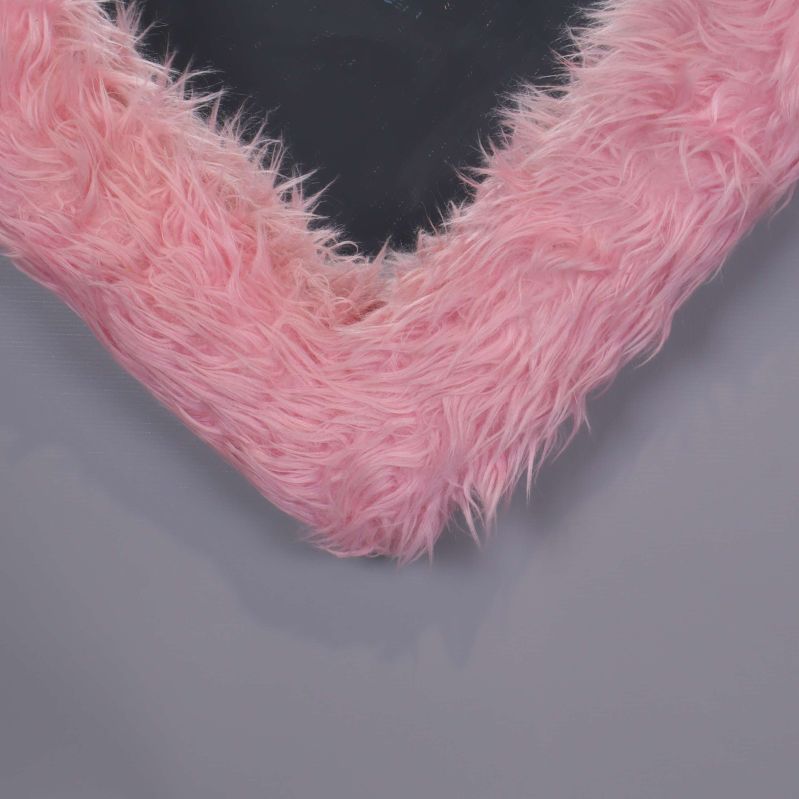 Nedre detalj av hjärtformad spegel med rosa fluffram