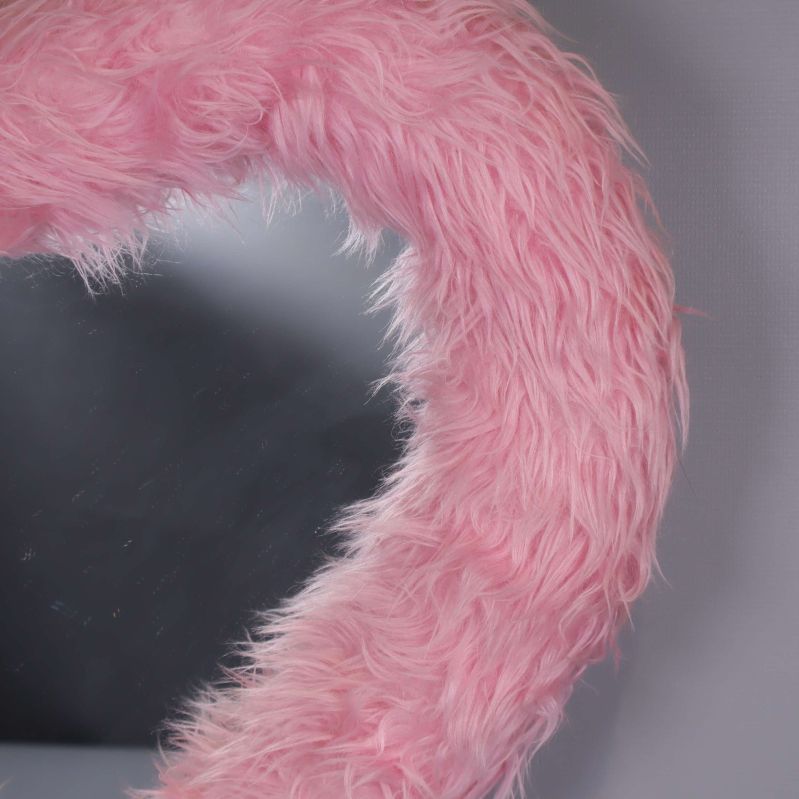 Närbild på den fluffiga rosa ramen på spegeln