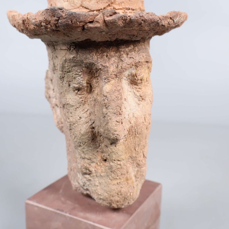 Närbild på skulpturens ansikte med grova detaljer