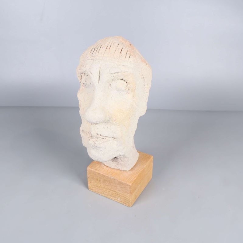Skulpturhuvud på träbas från sned vinkel