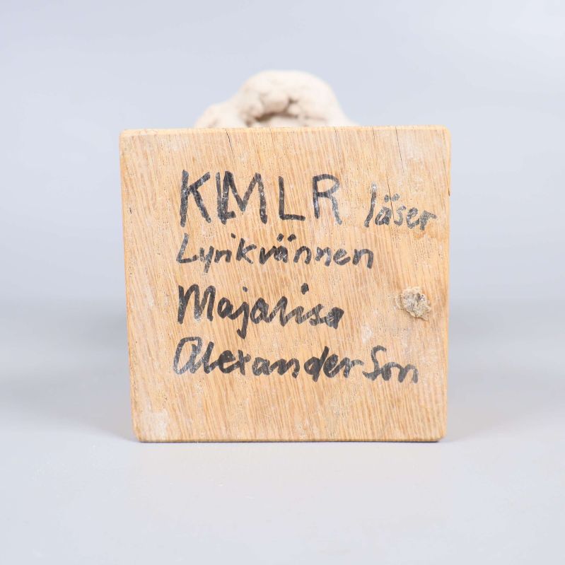 Träbasens undersida med handskriven text av konstnären