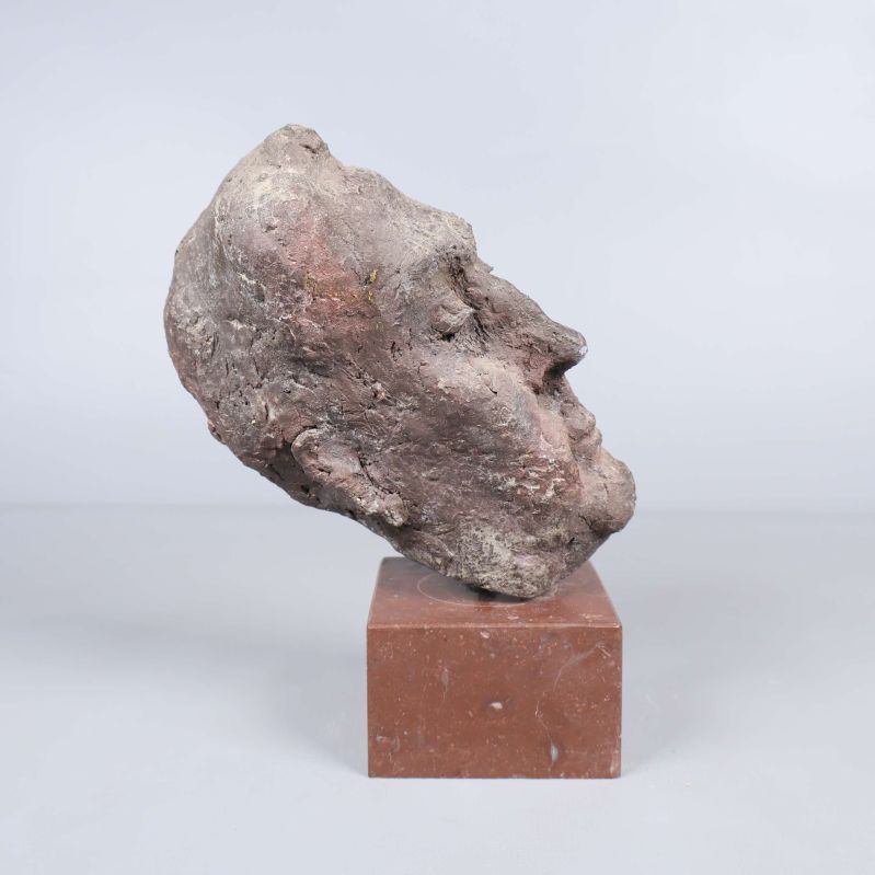 Skulptur i profil på brun kvadratformad sockel