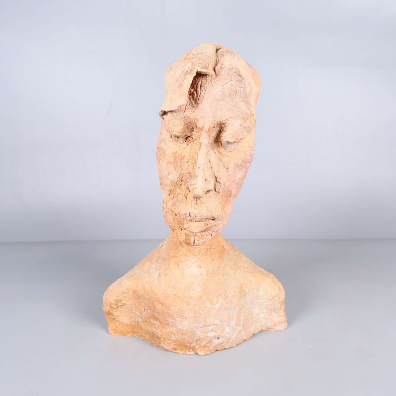 Handgjord skulptur av ett huvud och axlar mot ljus bakgrund