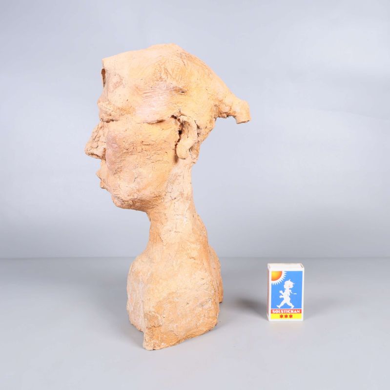 Profilvy av skulptur med tändsticksask som storleksreferens