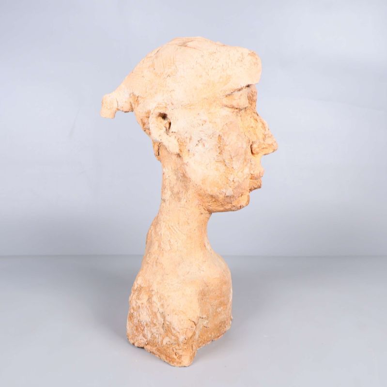 Skulptur sedd från vänster sida mot grå bakgrund