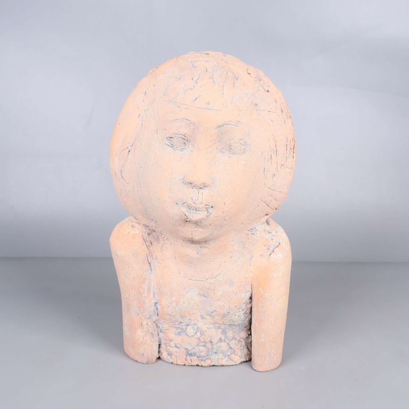 Skulptur med ansikte och armar framifrån mot grå bakgrund