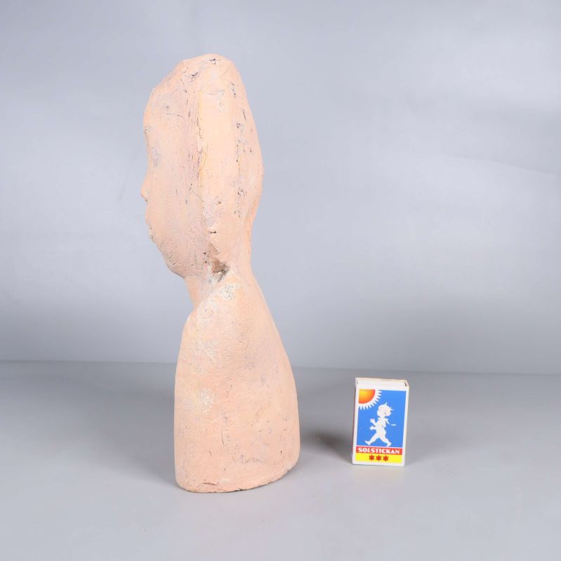 Skulpturens sida jämte tändsticksask för storleksjämförelse