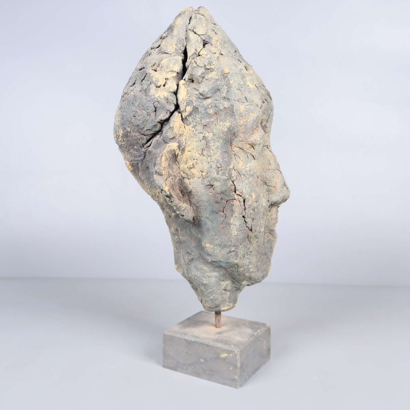 Profilvy av huvudformad skulptur på fot