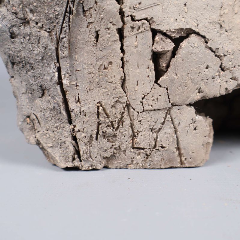 Signatur inristad i leran på skulpturen