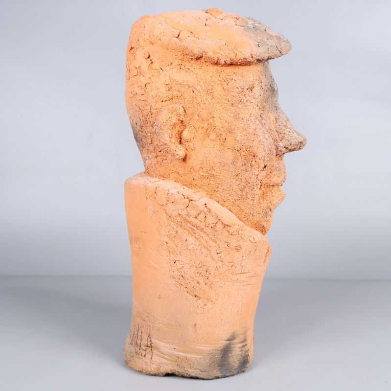 Sidosikt av abstrakt huvudskulptur i rödbrun och beige