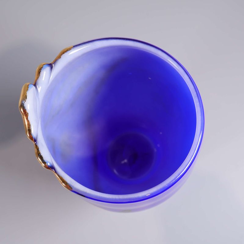 Vy uppifrån på blå vas med oregelbunden kant och gulddetalj