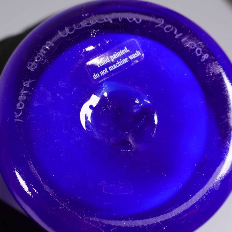 Undersidan av blå Kosta Boda vas med handmålad etikett