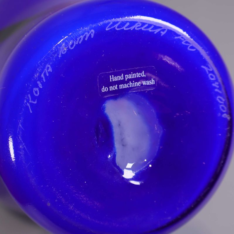 Närbild av vasens botten med klistermärke och gravyr