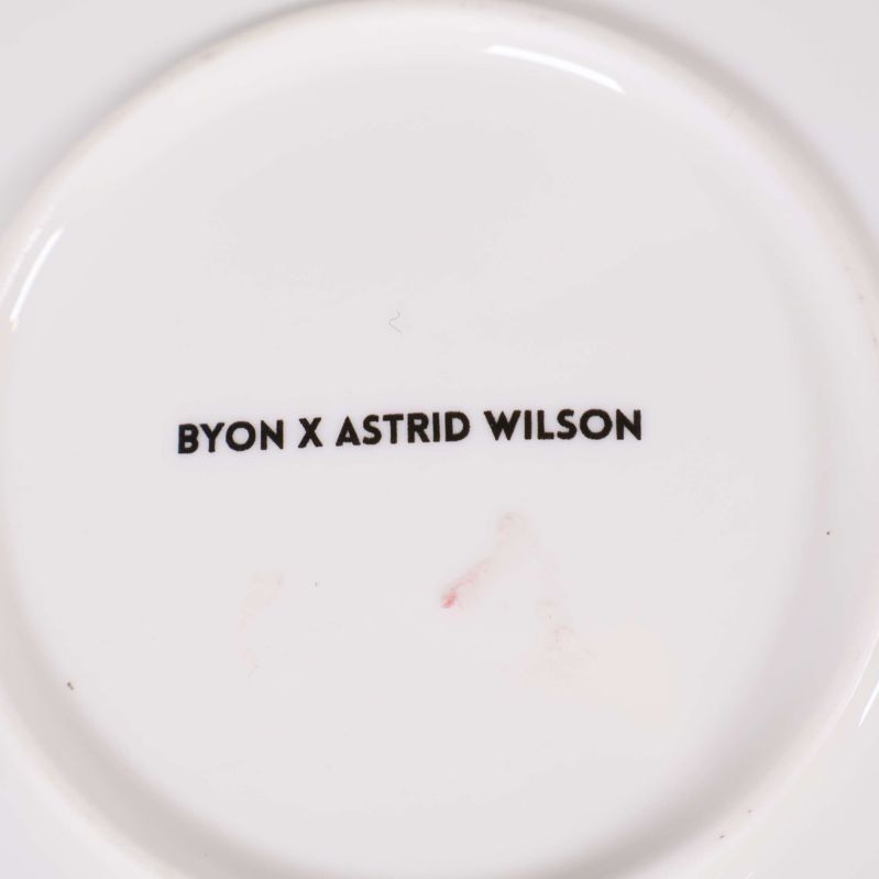Stämpel med texten BYON X ASTRID WILSON på tallrikens undersida