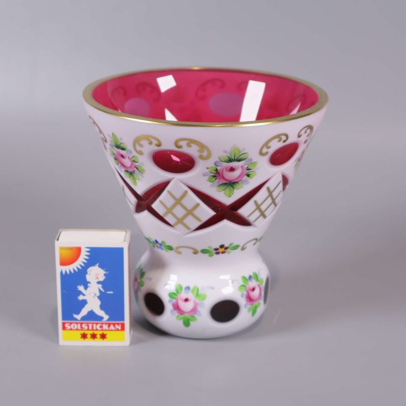 Vas med blommor och gulddekor bredvid tändsticksask