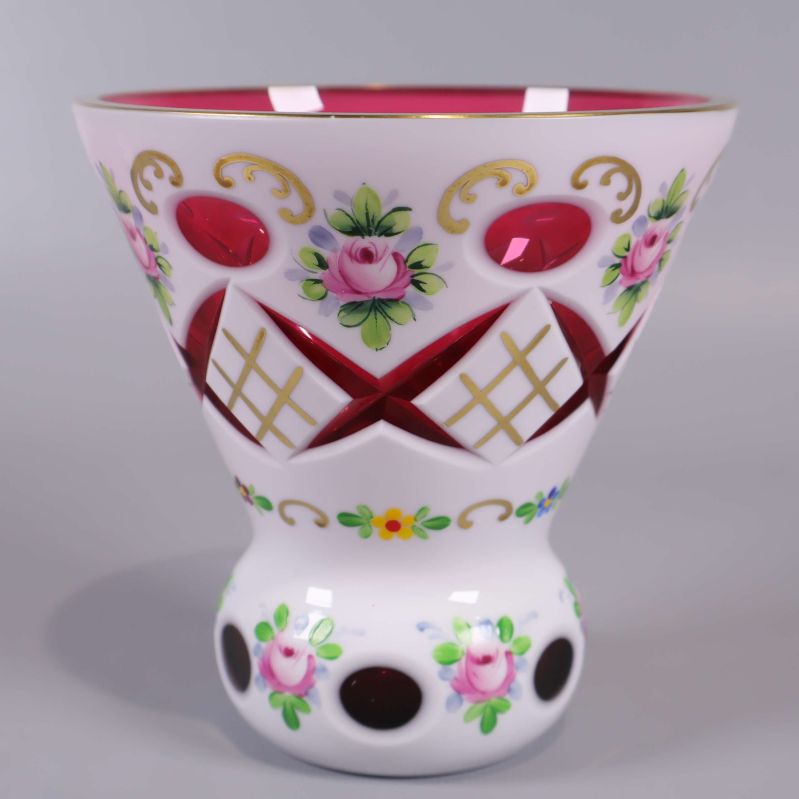 Närbild på vasens dekorativa utsida med blommor och guldmönster