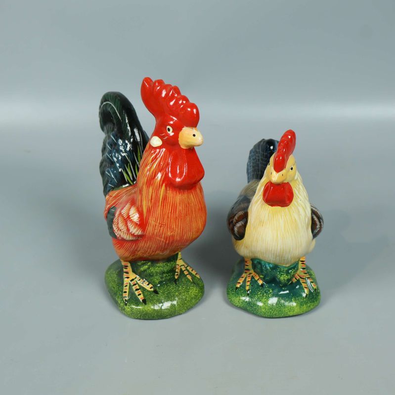 Två målade keramiktuppar stående bredvid varandra