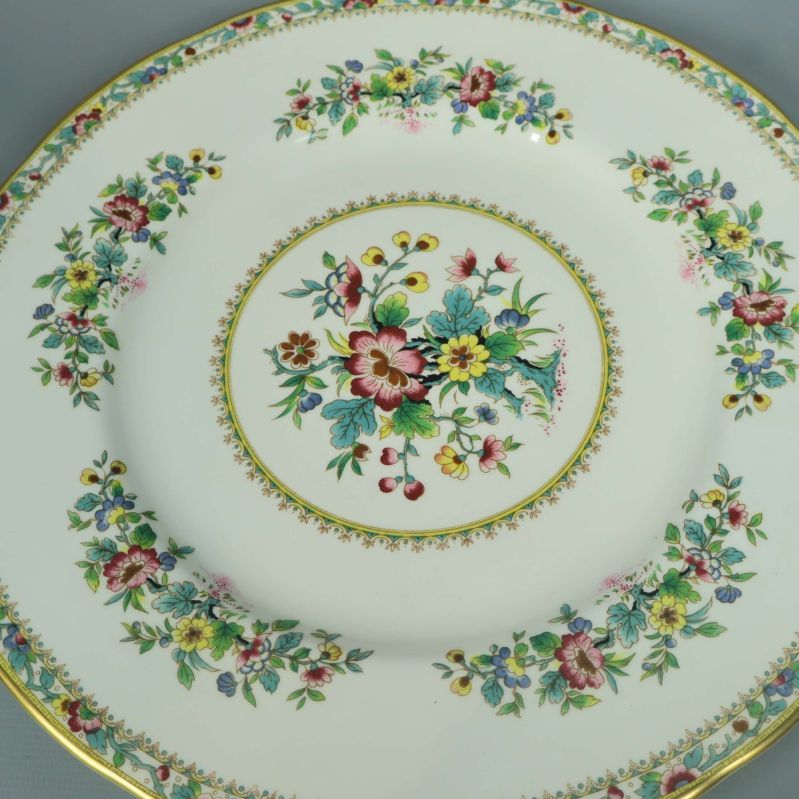 Detalj närbild på blommönster och guldkant på tallrik