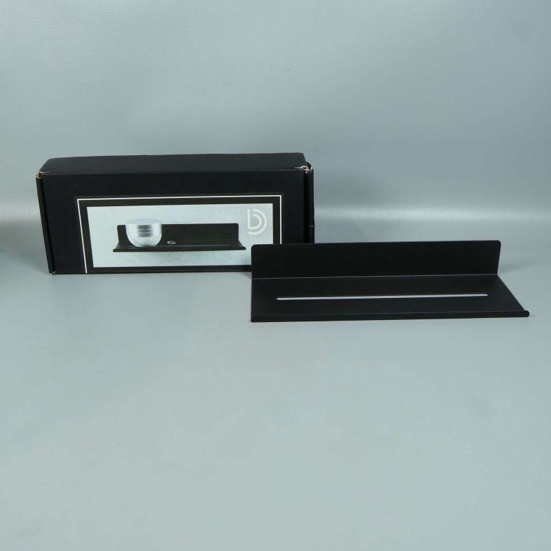 Svart metallhylla med originalförpackning bakom