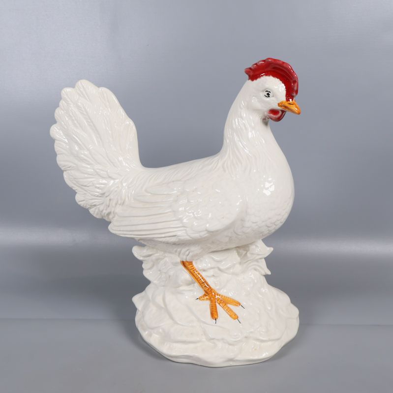 Vit keramisk kyckling i profil mot grå bakgrund