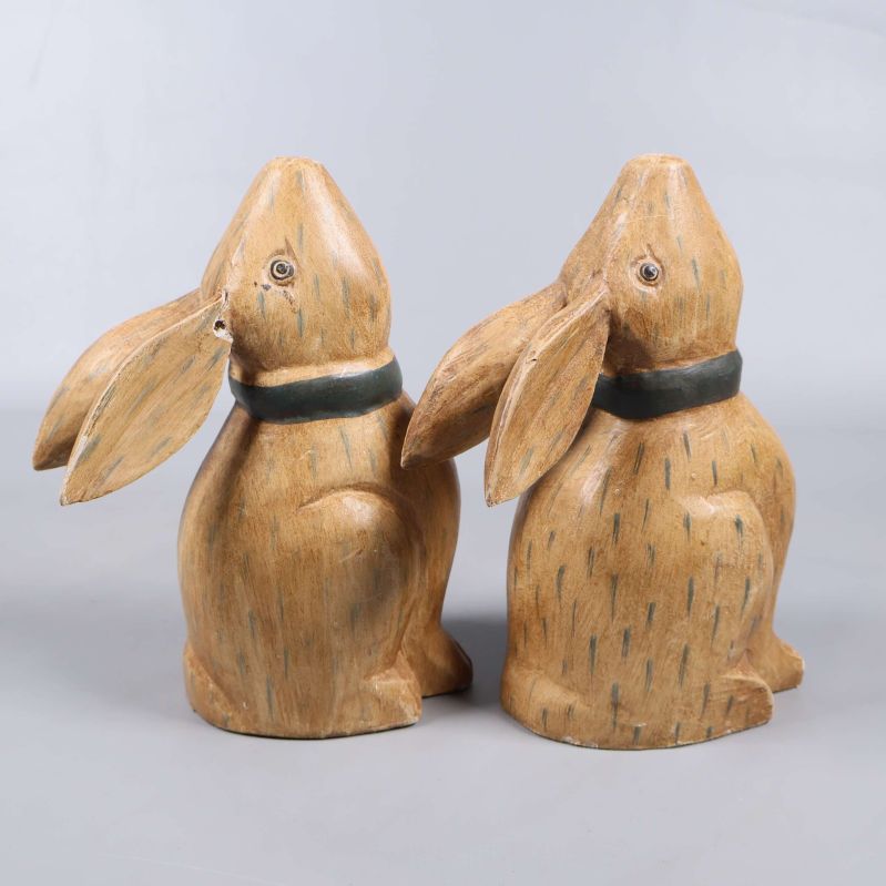 Två dekorativa kaniner i gips står bredvid varandra