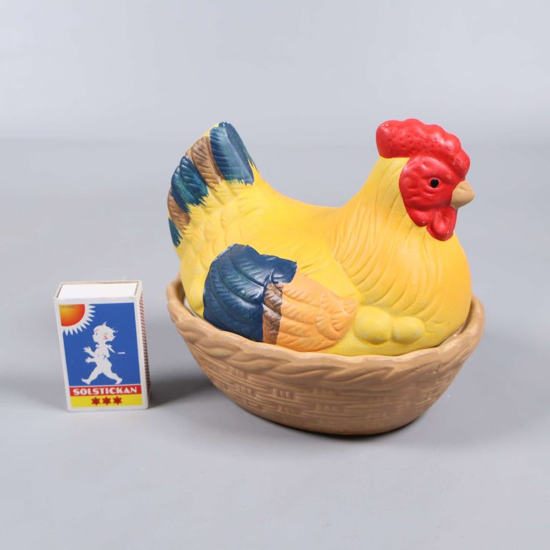 Keramikburk formad som höna bredvid tändsticksask