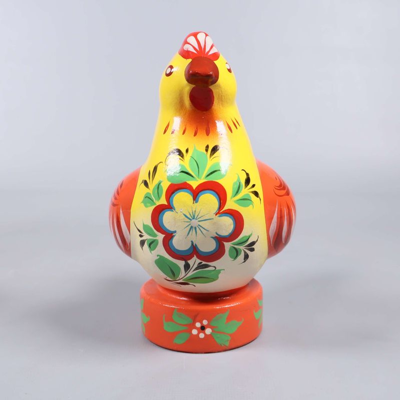 Framifrån på gul och röd träfigur höna