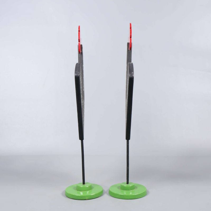 Två tupp dekorationer stående i profil mot ljus bakgrund