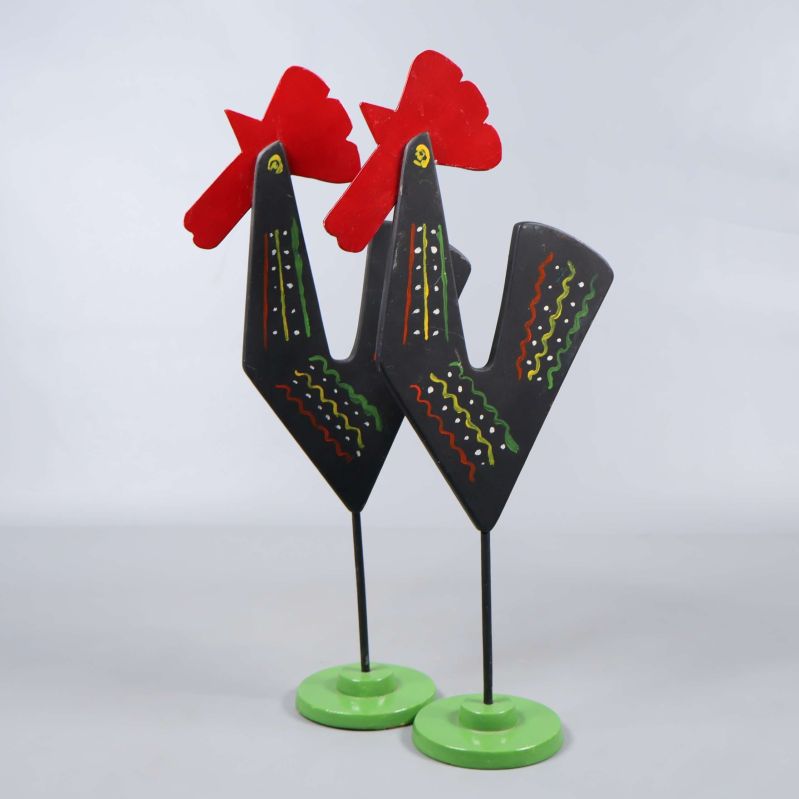 Två färgglada tupp dekorationer framifrån, ståendes på gröna baser