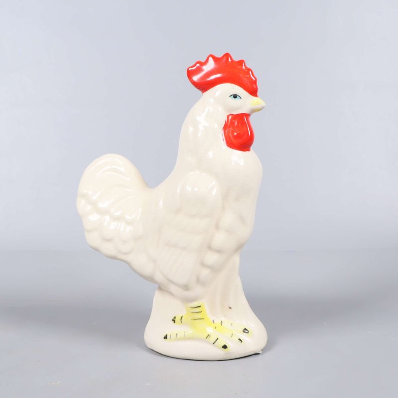 Keramisk tuppfigur sedd i profil från vänster